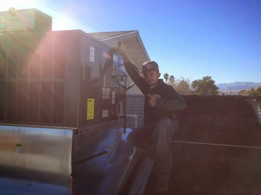 HVAC technician performing Air Duct Cleaning on a rooftop unit in Sparks
